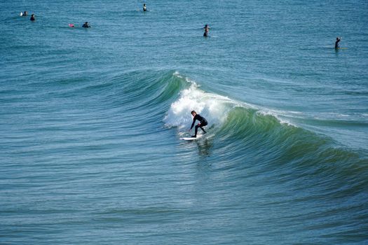 Male surfers enjoying the big wave in Oceanside in North San Diego, California, USA. Travel destination in the South West Coast famous for surfer. January 2n, 2021