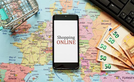 Mobile phone, shopping cart and money. Online shopping concept.