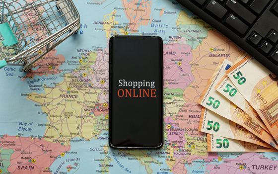 Mobile phone, shopping cart and money. Online shopping concept.