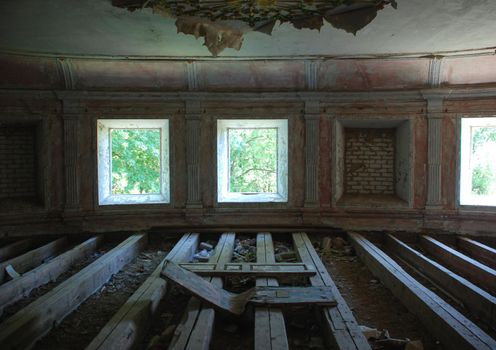 habitation of homeless man inside in abandoned house. Peeling walls, trash on the floor, window