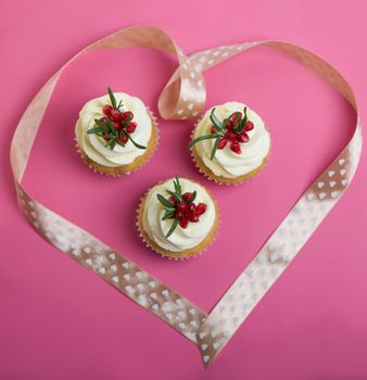 Valentines cupcakes with vanilla icing and decorated with ribbon heart.