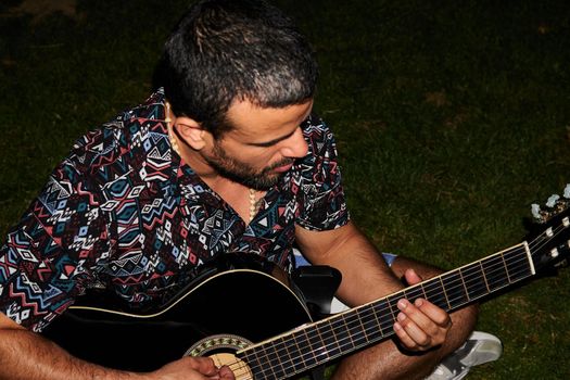 musician playing an instrument in the park at night