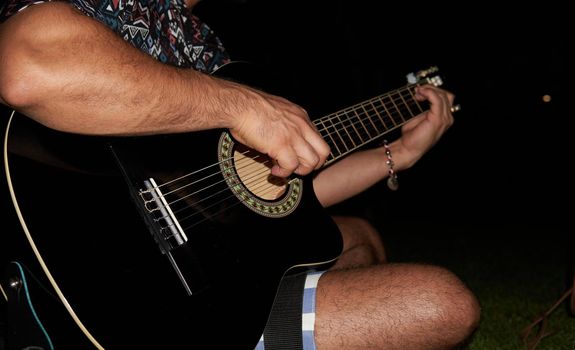 musician playing an instrument in the park at night