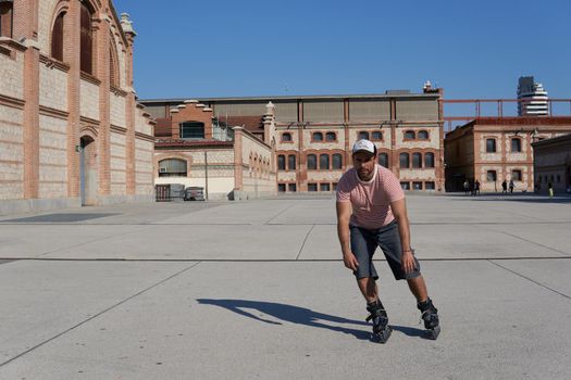 Man skating in cap between buildings