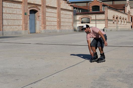 Man skating in cap between buildings