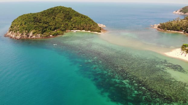 Aerial drone view small Koh Ma island, Ko Phangan Thailand. Exotic coast panoramic landscape, Mae Haad beach, summer day. Sandy path between corals. Vivid seascape, mountain coconut palms from above