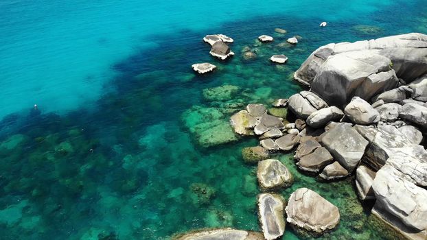 Calm sea water near stones. Peaceful blue sea water and gray boulders in perfect place for snorkeling on Koh Tao Island on sunny day in Thailand. Natural background texture