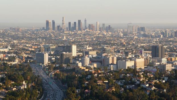 Highrise skyscrapers of metropolis and busy rush hour highway, Los Angeles, California USA. Urban downtown skyline and traffic jam. Aerial view of cityscape and cars on driveway. Freeway in LA city.