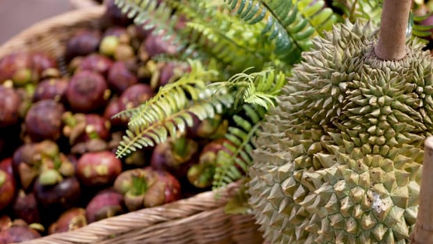 Fruits and vegetables on rustic stall. Assorted fresh ripe fruits and vegetables placed on rustic oriental stall in market. sweet tropical purple mangosteen and durian on foreground