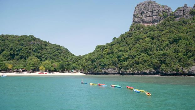 Islands in ocean at Ang Thong National Marine Park near touristic Samui paradise tropical resort. Idyllic turquoise sea natural background with copy space. Kayaks and colorfull sports canoes.