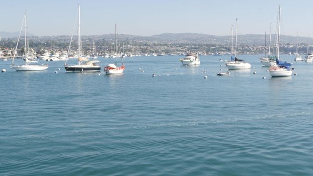 Newport beach harbor, weekend marina resort with yachts and sailboats, Pacific Coast, California, USA. Waterfront luxury suburb real estate in Orange County. Expensive beachfront holiday destination.