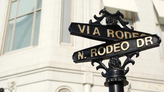 World famous Rodeo Drive symbol, Cross Street Sign, Intersection in Beverly Hills. Touristic Los Angeles, California, USA. Rich wealthy life consumerism, Luxury brands and high-class stores concept