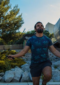 Man playing sports in a park in the afternoon and wearing a flower T-shirt