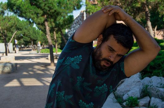 Man playing sports in a park in the afternoon and wearing a flower T-shirt