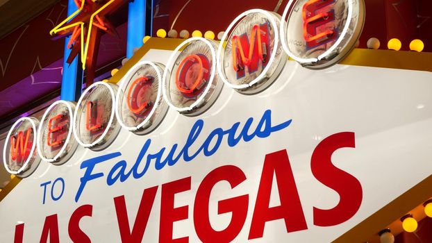 Welcome to fabulous Las Vegas retro neon sign in gambling tourist resort, USA. Iconic vintage glowing banner, symbol of casino, games of chance, money playing and hazard bets. Illuminated signboard.