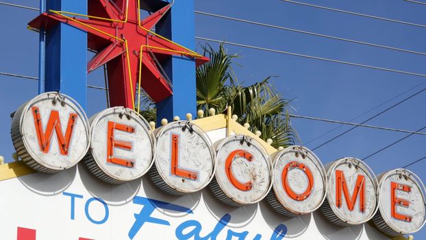 Welcome to fabulous Las Vegas retro neon sign in gambling tourist resort, USA. Iconic vintage banner as symbol of casino, games of chance, money playing and hazard betting. Lettering on signboard.
