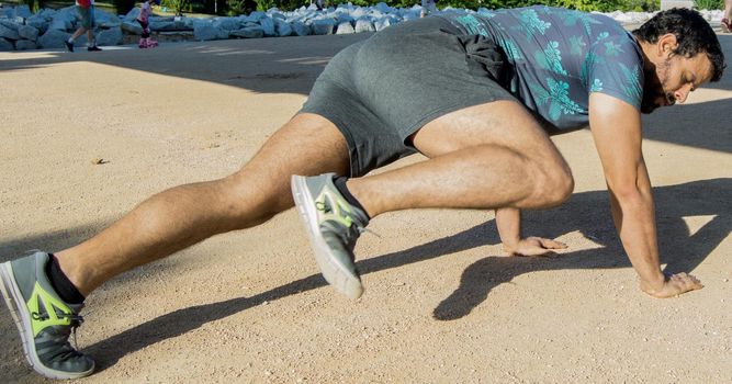 Man playing sports in a park in the afternoon and wearing a flower T-shirt