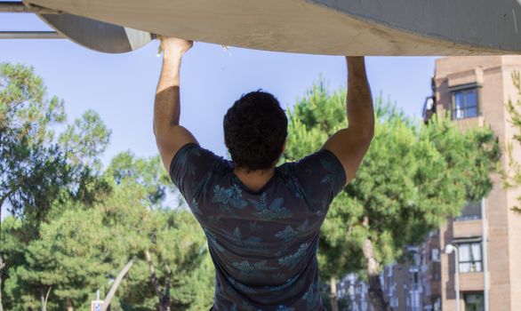 Man playing sports in a park in the afternoon and wearing a flower T-shirt