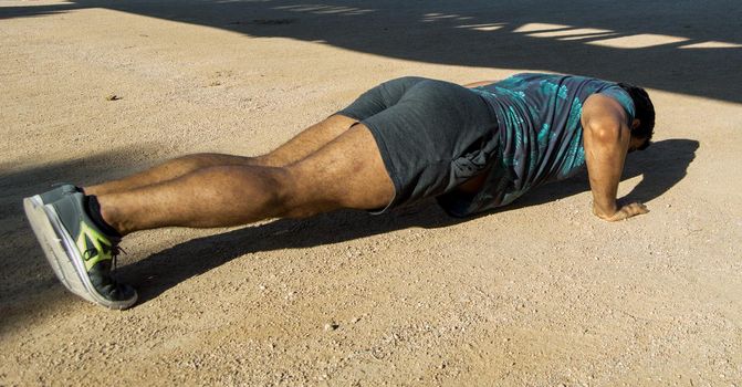 Man playing sports in a park in the afternoon and wearing a flower T-shirt