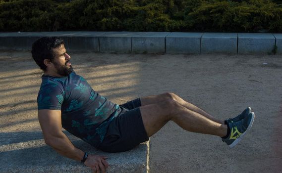 Man playing sports in a park in the afternoon and wearing a flower T-shirt