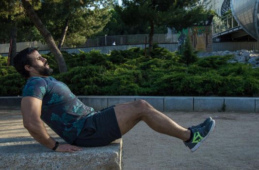 Man playing sports in a park in the afternoon and wearing a flower T-shirt