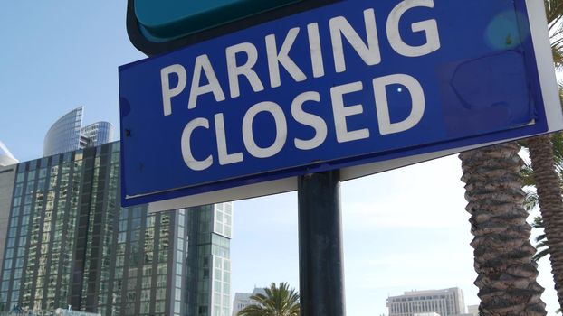 Parking lot sign as symbol of traffic difficulties and transportation issues in busy urban areas of USA. Public paid parking zone in downtown of San Diego, California. Limited space for cars in city.