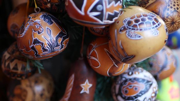 Wooden ornamental handmade mexican decor. Indigenous souvenirs hanging on new year tree, handicraft market, California USA. Hispanic authentic pattern, folk traditional handiwork from Latin America.
