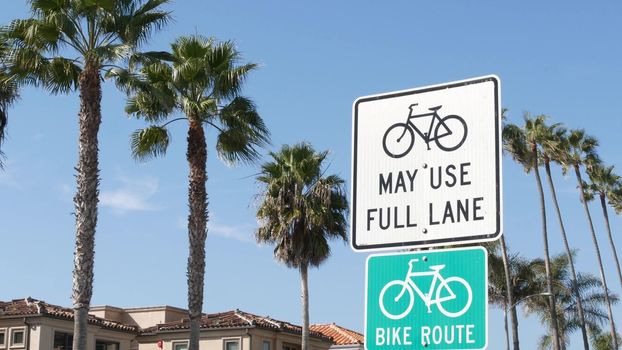 Bike Route green road sign in California, USA. Bicycle lane singpost. Bikeway in Oceanside pacific tourist resort. Cycleway signboard and palm. Healthy lifestyle, recreation and safety cycling symbol.