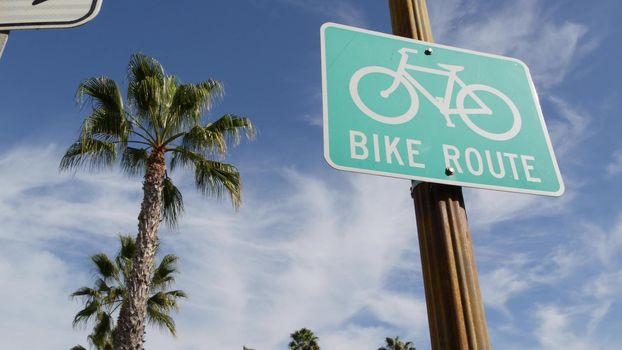 Bike Route green road sign in California, USA. Bicycle lane singpost. Bikeway in Oceanside pacific tourist resort. Cycleway signboard and palm. Healthy lifestyle, recreation and safety cycling symbol.