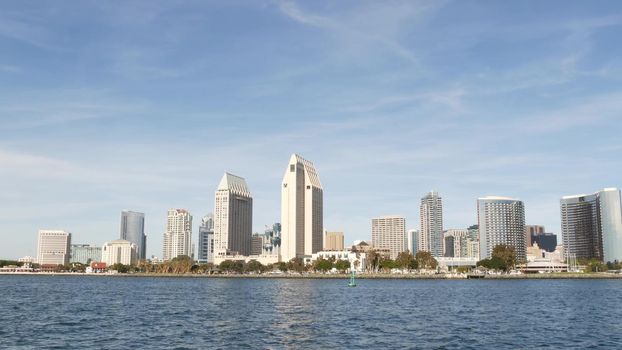 Metropolis urban skyline, highrise skyscrapers of city downtown, San Diego Bay, California USA. Waterfront buildings near pacific ocean harbour. View from boat, nautical public transport to Coronado.