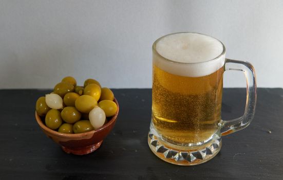 Black-based beer mug with olives