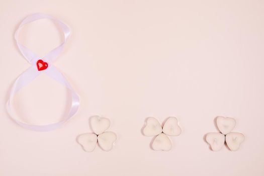 March 8, composition of hearts on a pink background. View from above. Space for text, flat lay