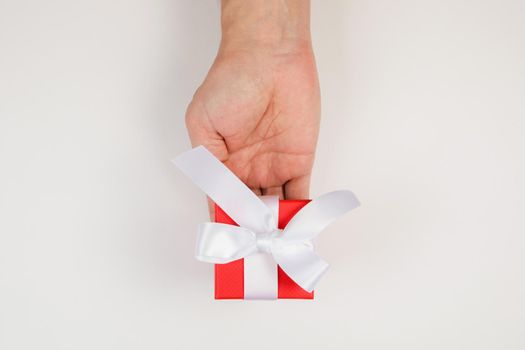 Gift box in men's hands for a holiday. View from above. Flat lay