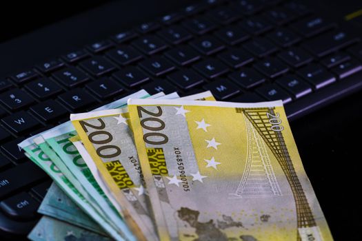 Euro  banknotes on keyboard. Selective focus on stack euro money.