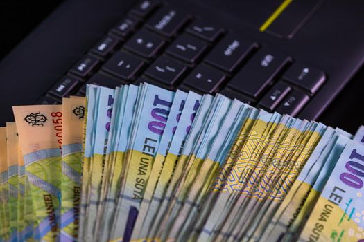 Lei banknotes on keyboard. Selective focus on stack of LEI romanian money.