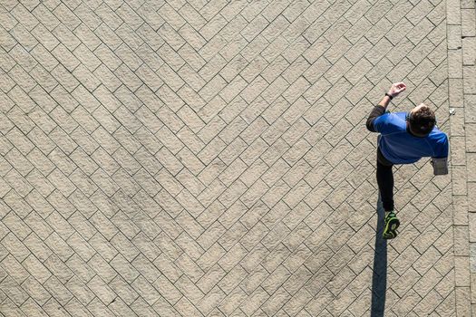 view from above of a young man running over a steel mill