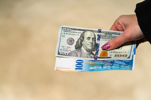 Woman hand holding and giving money. World money concept, close up of 100 swiss franc banknote and 100 US dollar, photo of CHF and USD currency