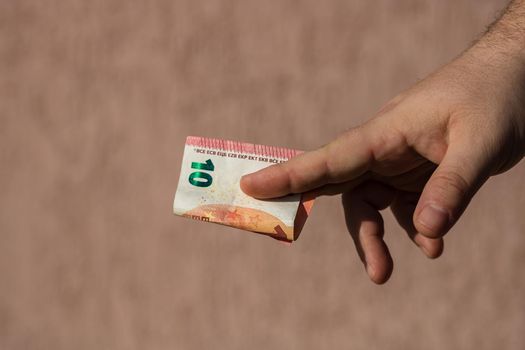 Man hands giving money like a bribe or tips. Holding EURO banknotes on a blurred background, EU currency