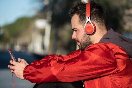 young man in sportswear listening to music with a pair of headphones