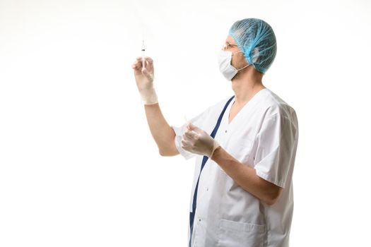 Surgeon holds a syringe in his hands and releases air bubbles from it, isolated on white background