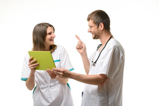 Two doctors have fun discussing information on a tablet