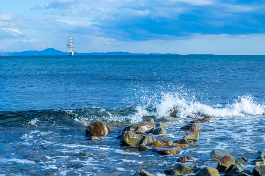 Seascape with a beautiful sailboat on the horizon. Vladivostok, Russia.