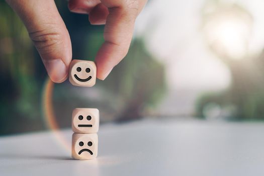 Smile face and cart icon on wood cube. Optimistic person or people feeling inside and service rating when shopping, satisfaction concept in business.