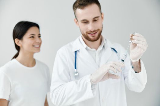 happy female patient looking at syringe with covid-19 vaccine in doctor's hands. High quality photo