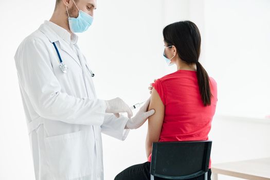 male doctor with a syringe in his hands make an injection in the patient's shoulder. High quality photo