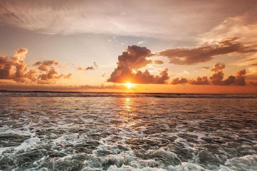 Colorful ocean beach sunset, cloudy sky and sea surf