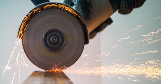 Sawing metal with circular saw sparks close up