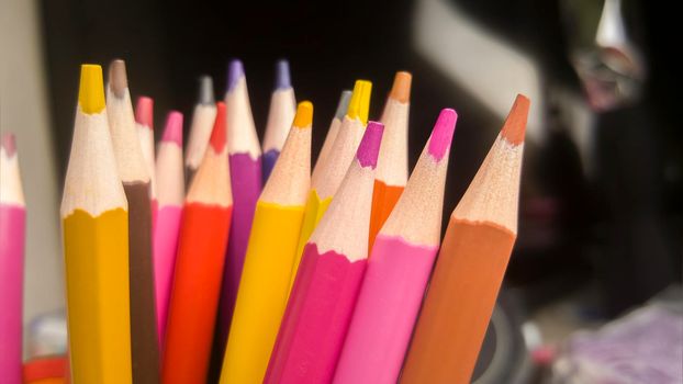 A set of colored pencils, stationery. A lot of multicolored pencils on the table.