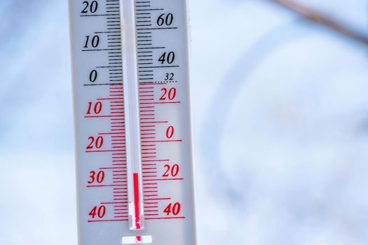 The thermometer lies on the snow in winter showing a negative temperature. Meteorological conditions in a harsh climate in winter with low air and ambient temperatures.Freeze in wintertime