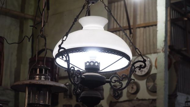 An old, vintage lamp with a shade in an antique store.